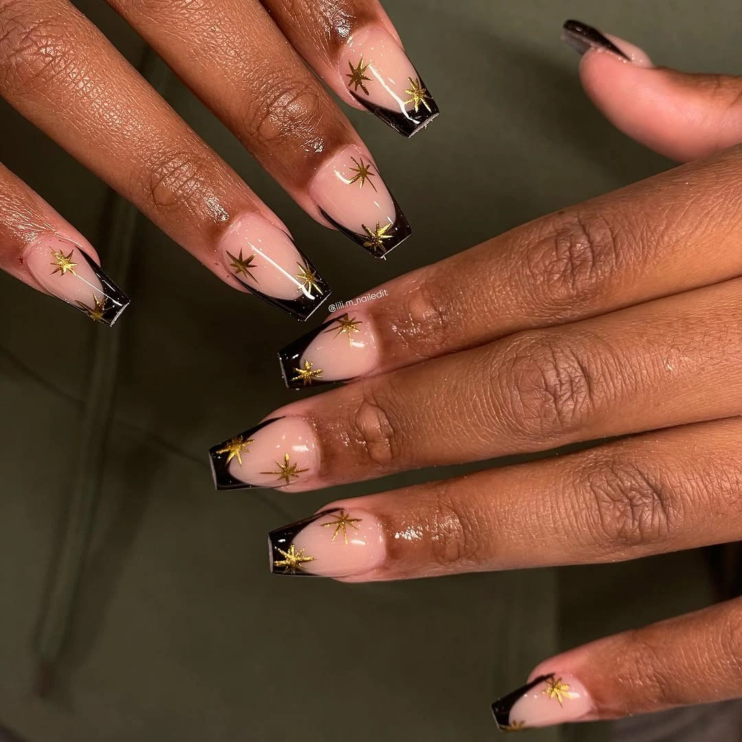 Pale pink square nails with black corners and gold accents