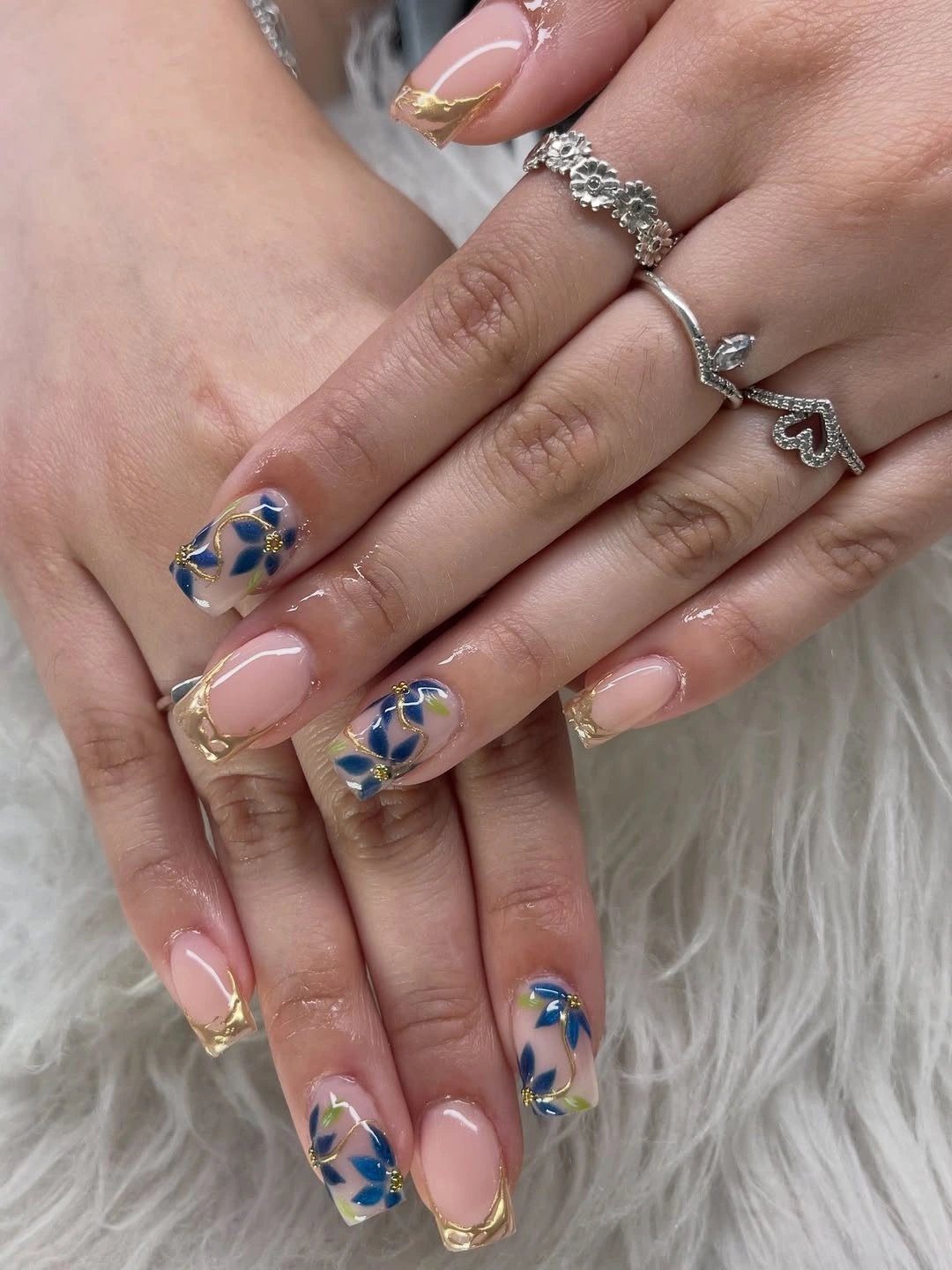 Pale pink square nails with blue floral and gold accents