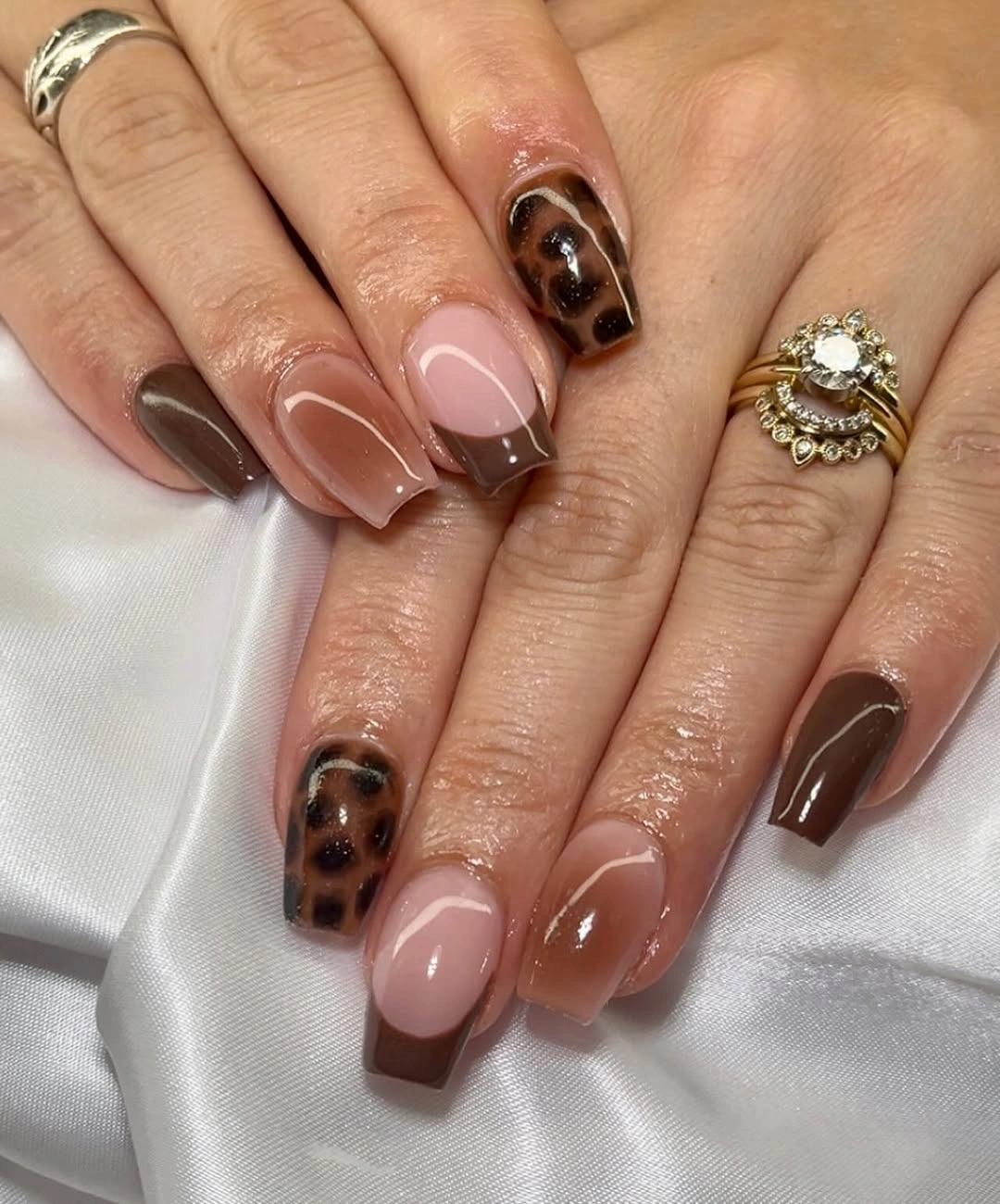 Blush pink square nails with brown animal-print accents