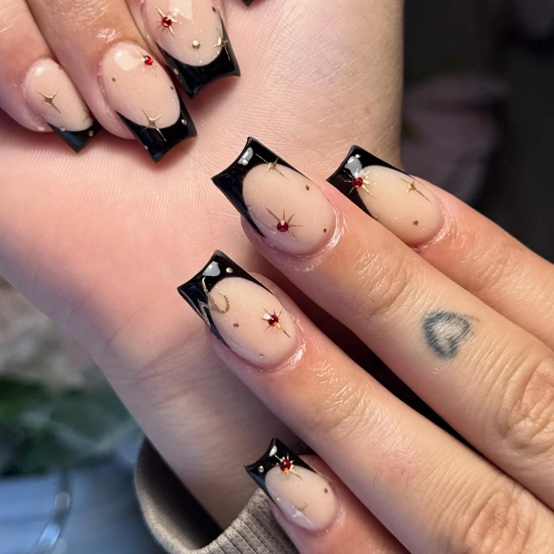Nude square nails with black tips and tiny red accents