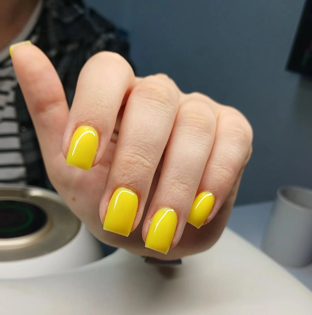 Medium square nails in vivid glossy yellow polish