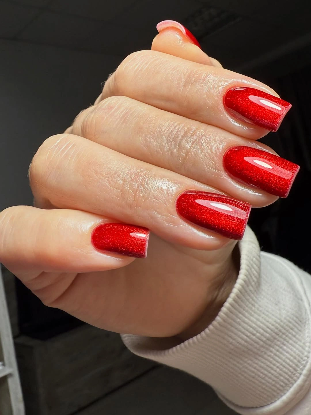 Medium square red nails with fine reflective sparkle
