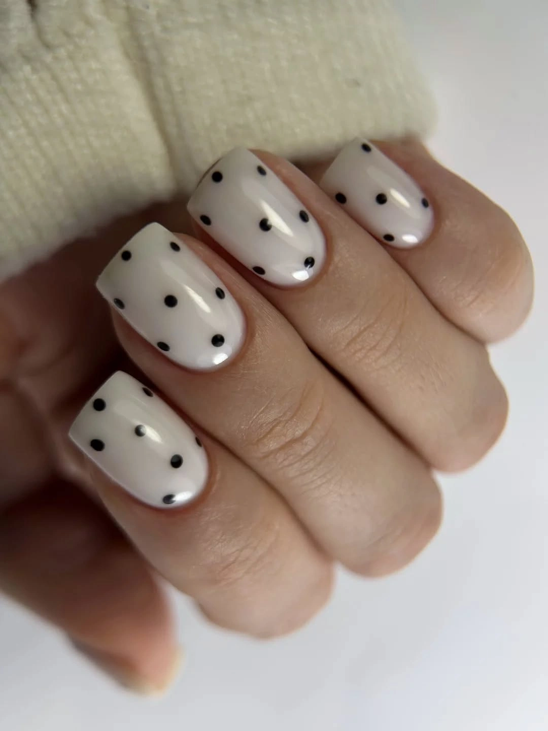 Short milky white square nails with evenly spaced black dots