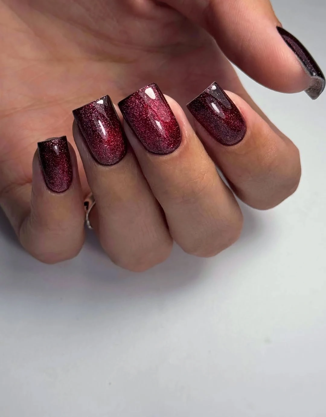 Medium square black cherry burgundy nails with fine sparkle