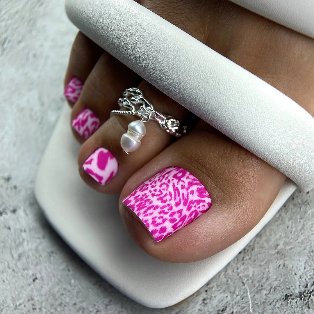 Bright pink and white patterned short square toenails in sandals