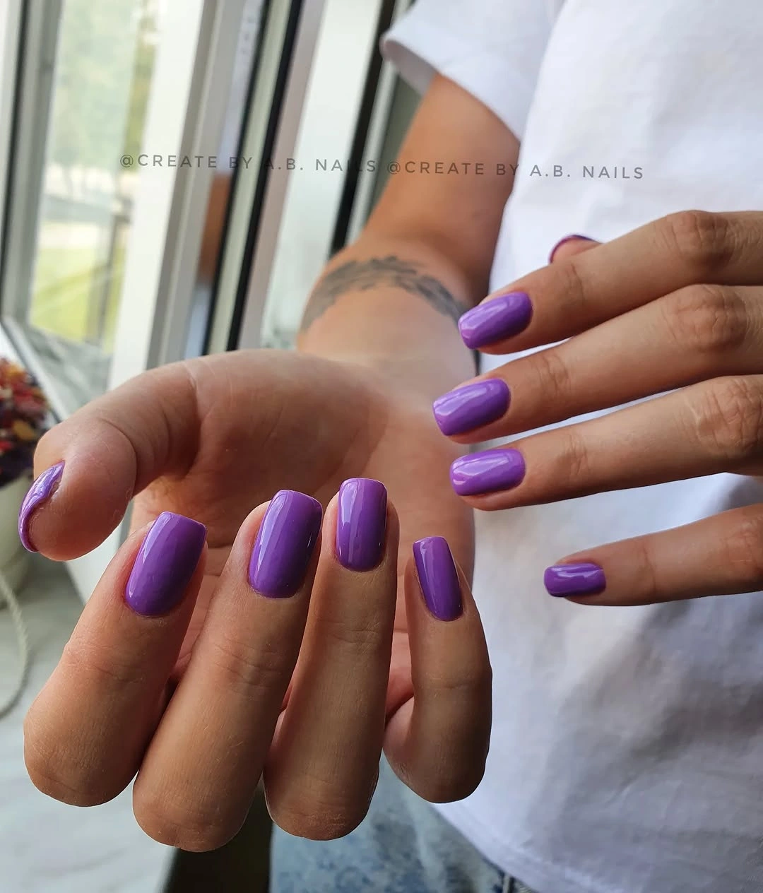 Short square glossy purple nails with a saturated clean finish