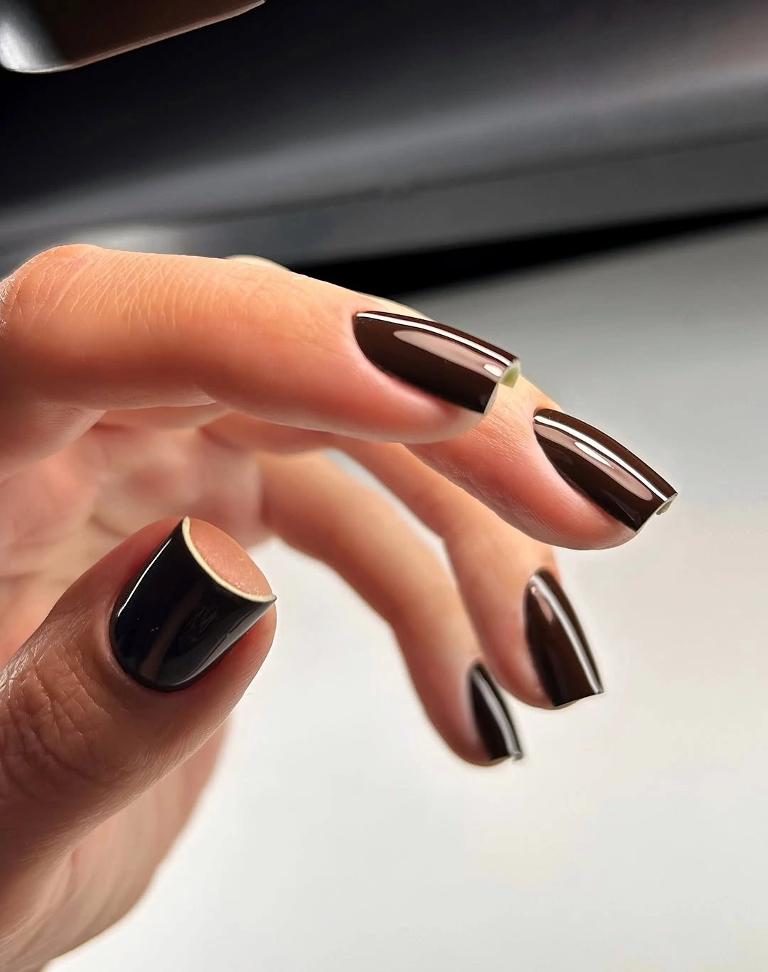 Short dark brown square nails with slim warm edge arcs