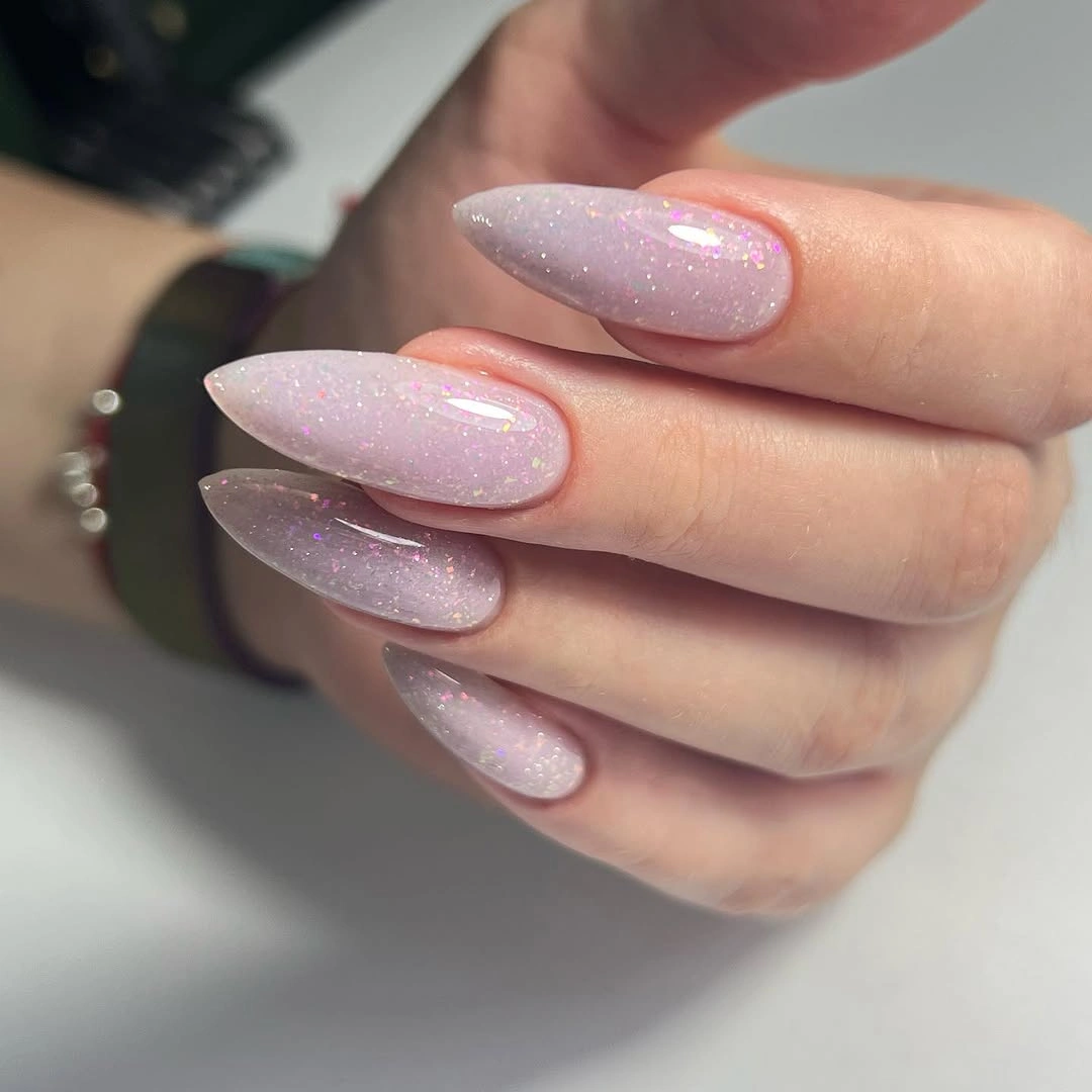 Translucent blush almond nails with fine iridescent sparkle