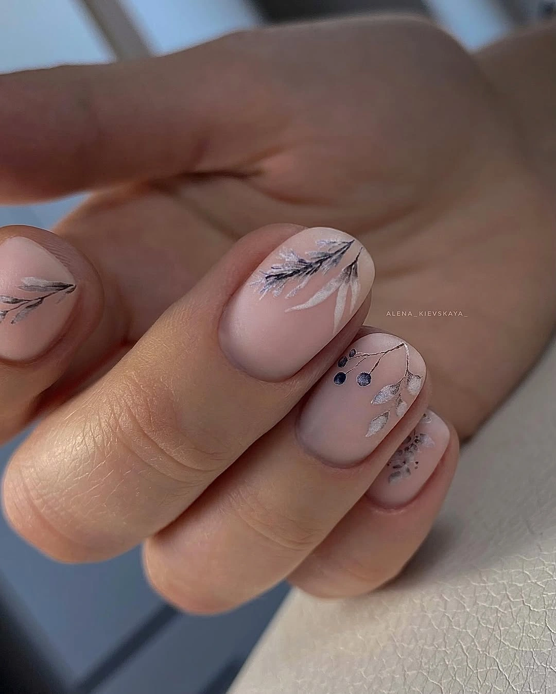 Short nude pink nails with delicate black botanical linework