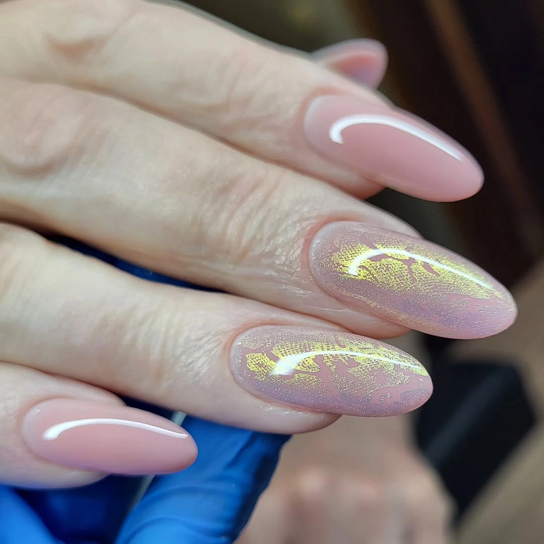Soft pink almond nails with irregular gold accents