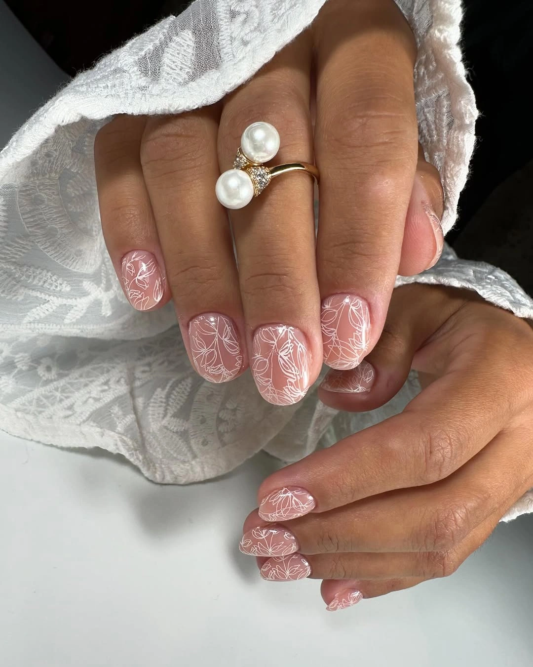 Short dusty rose nails with fine white floral lines