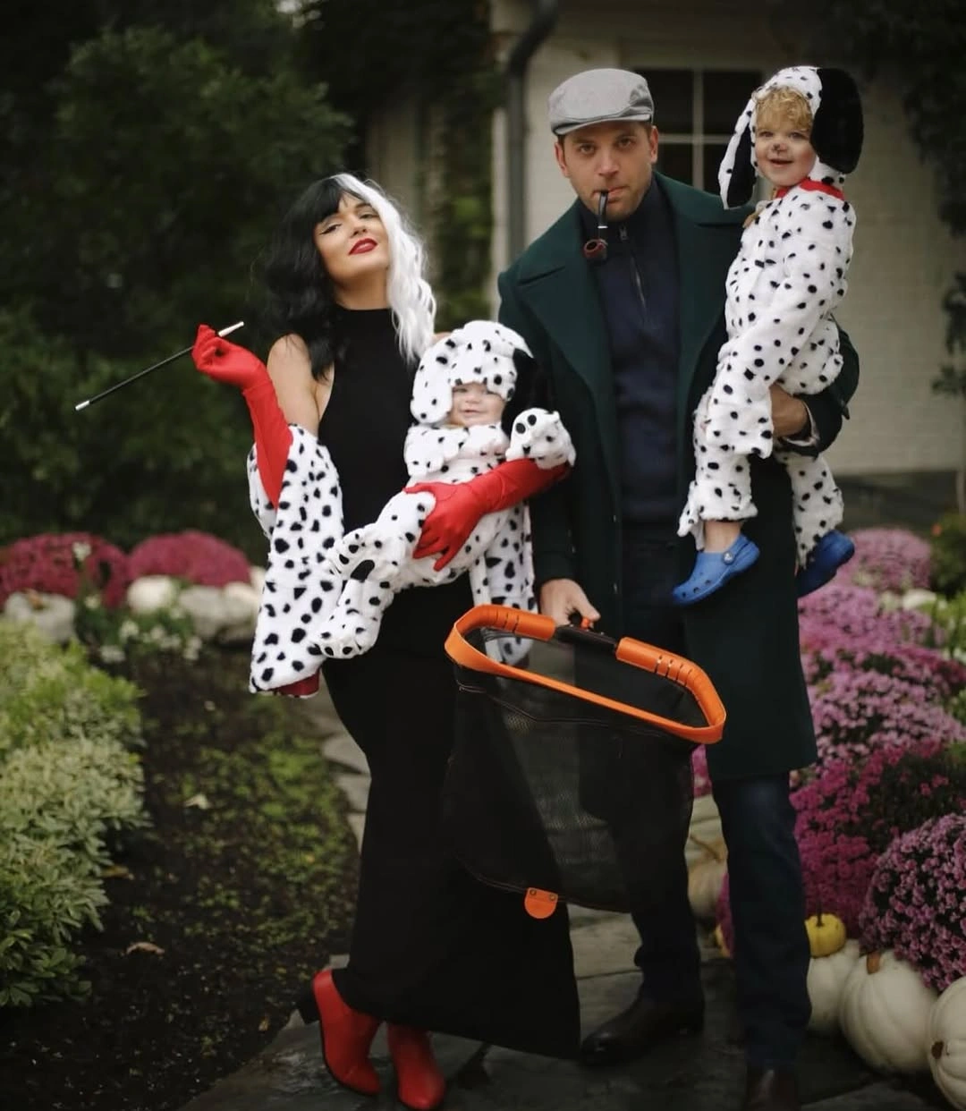 Family in black white spotted costumes with red accessory accents