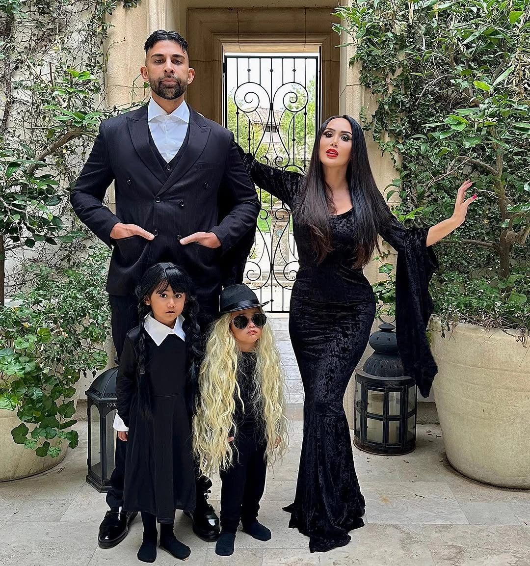 Family in dark formal costumes with one long blonde wig