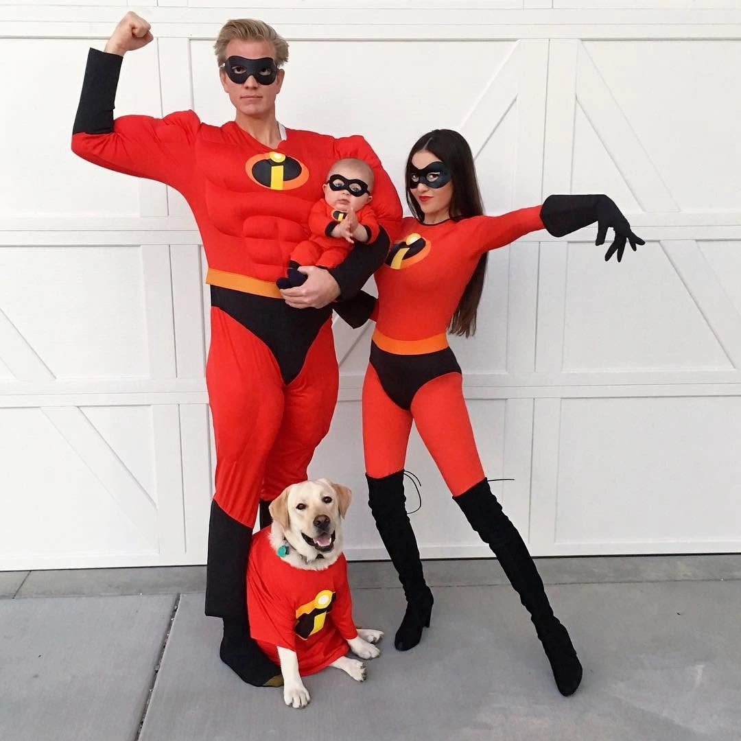 Family and dog in matching red superhero costumes with black masks