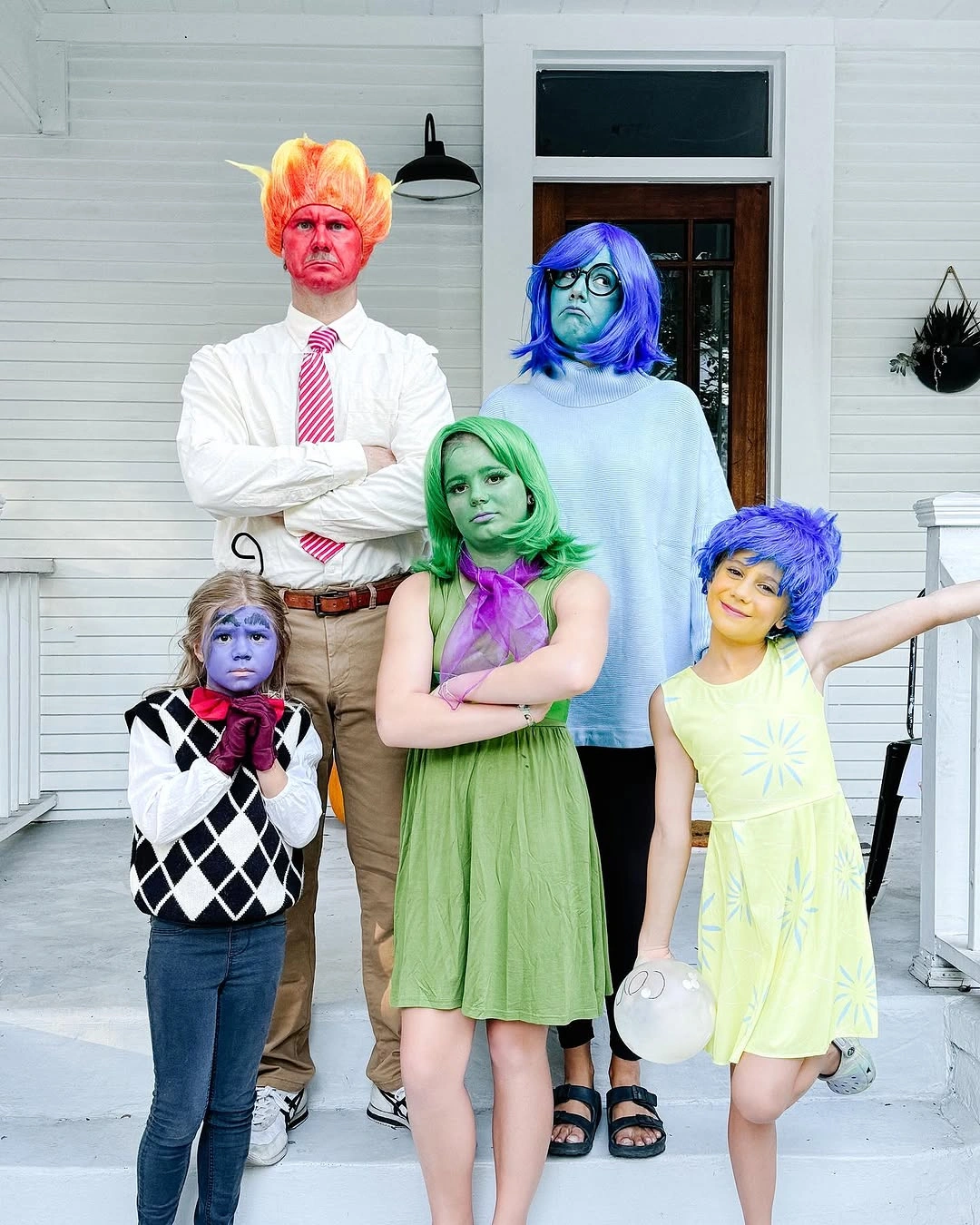 Family in colorful makeup wigs and simple Halloween costume clothes