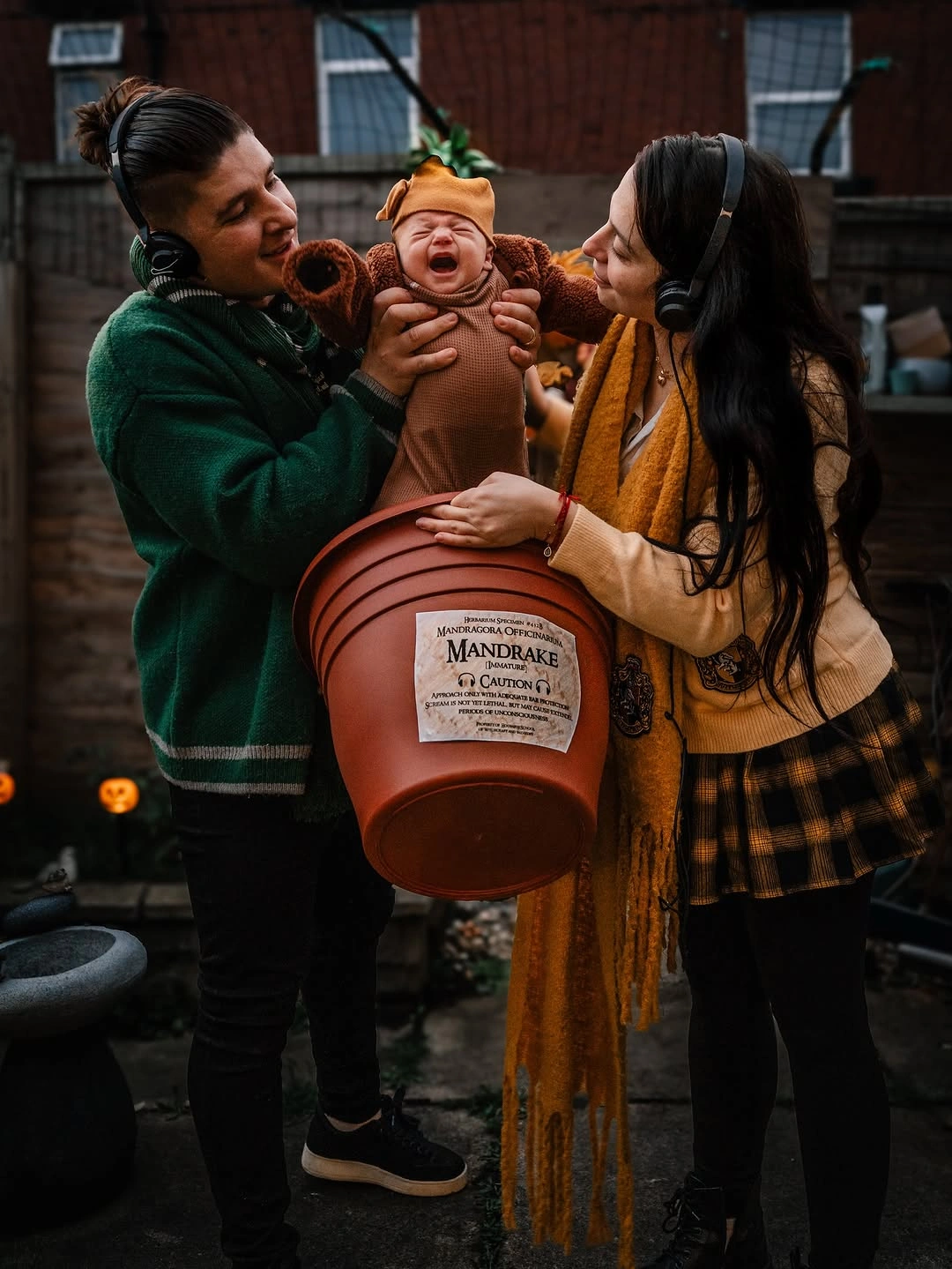 Parents in green and mustard with baby in a potted plant costume