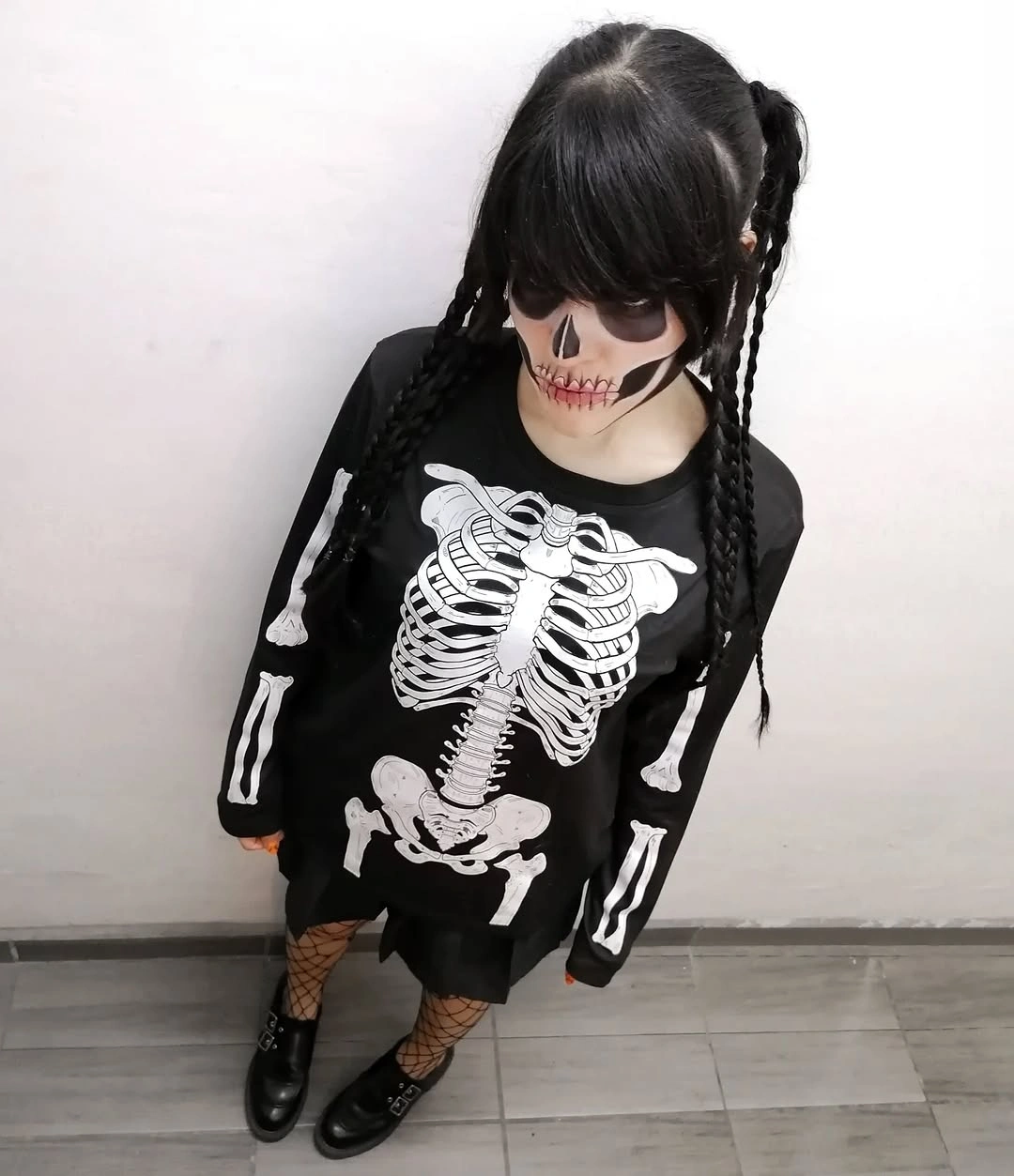 Black skeleton tunic with lace up sleeves fishnet tights braids and boots