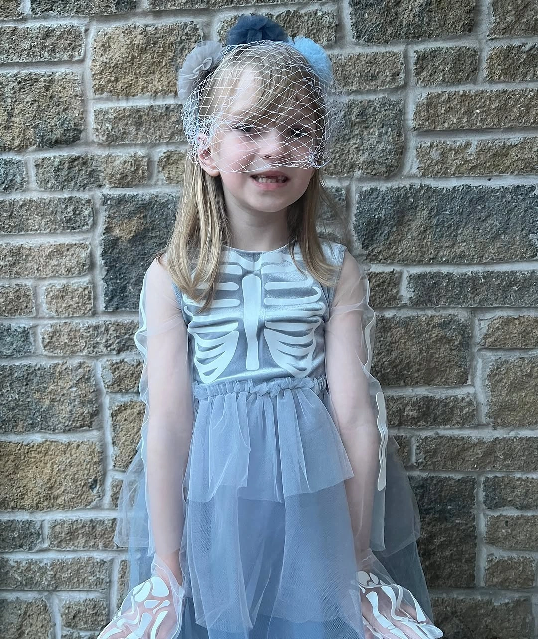 Light skeleton dress with sheer blue gray skirt floral headpiece and netting