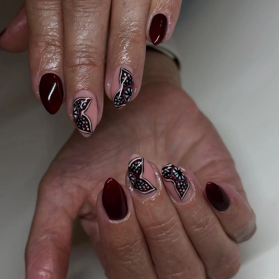 Short almond burgundy nude nails with delicate black details
