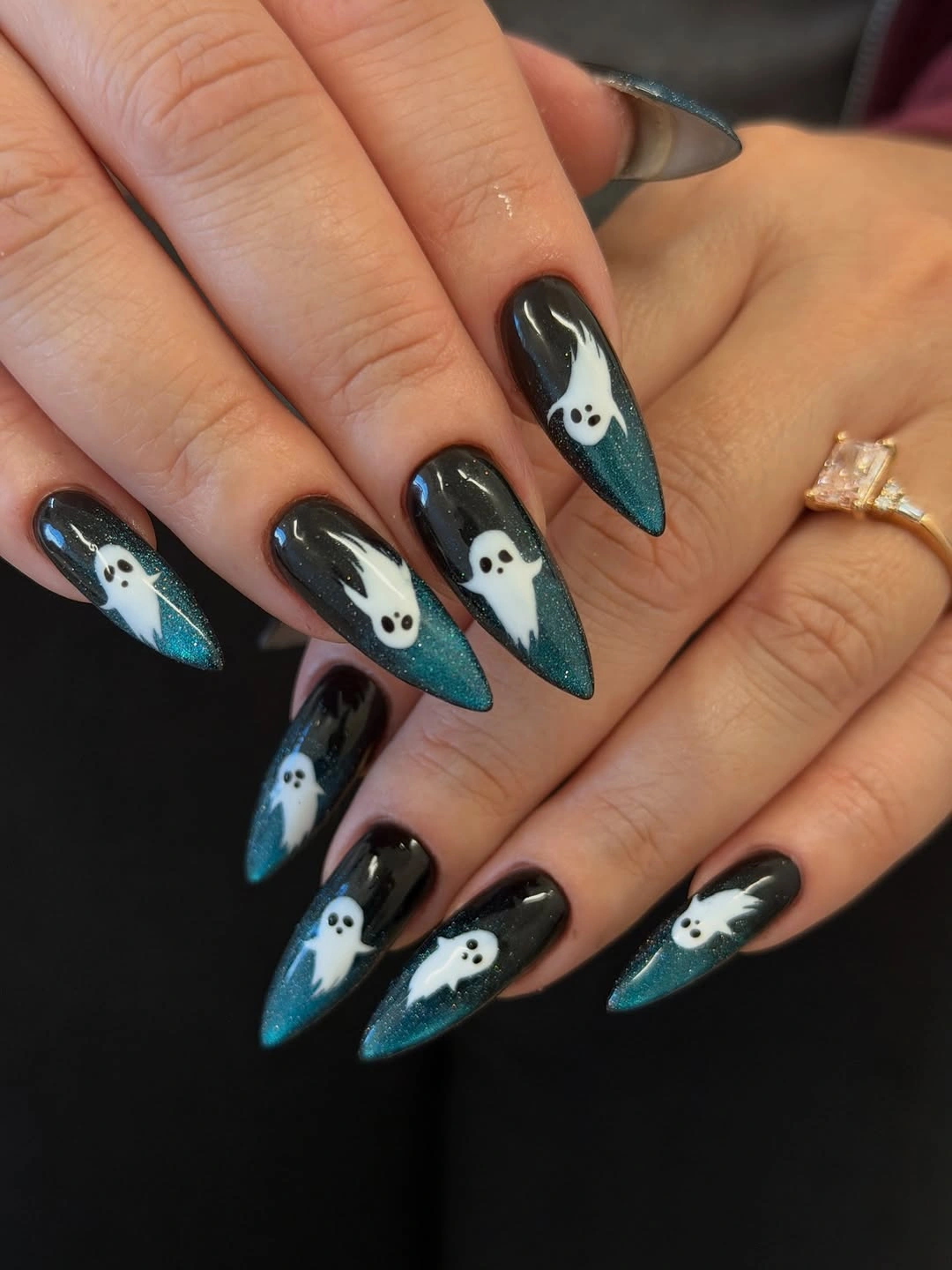 Long pointed black teal nails with repeated white ghost faces