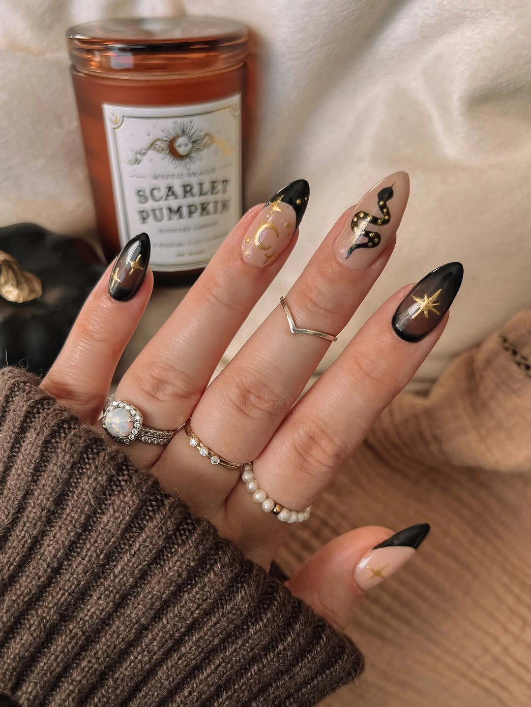 Long almond nude black nails with tiny celestial seasonal marks