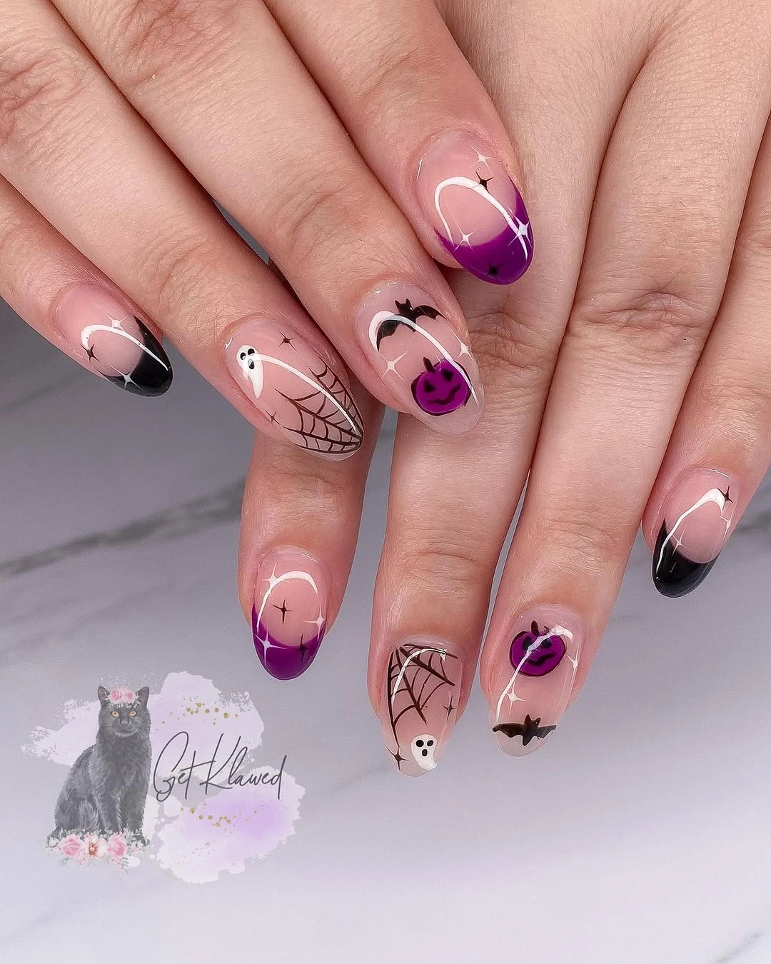 Medium almond pink nails with purple tips and black Halloween details