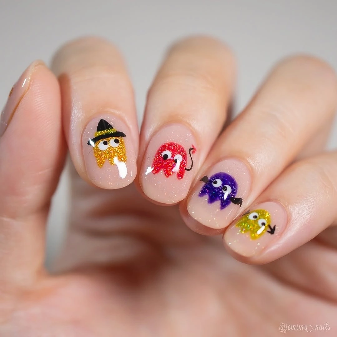 Short rounded colorful nails with tiny Halloween character faces