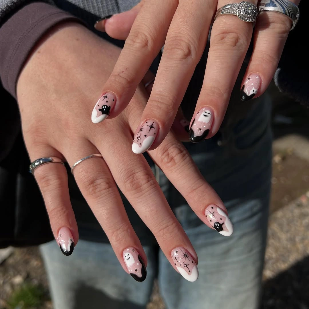 Short almond pink nails with small black Halloween line drawings