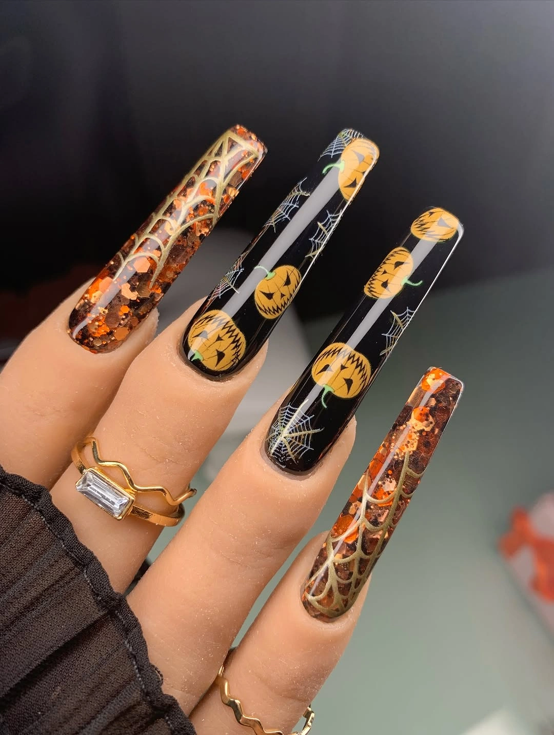 Long black coffin nails with pumpkins webs and clear orange glitter accents