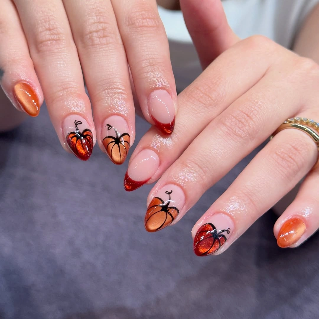 Soft pink nails with copper shimmer and small orange winged motifs