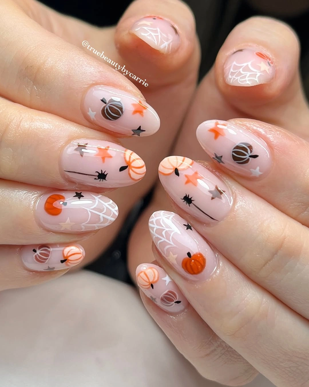 Short almond nails with pumpkins spiders webs stars and neutral base
