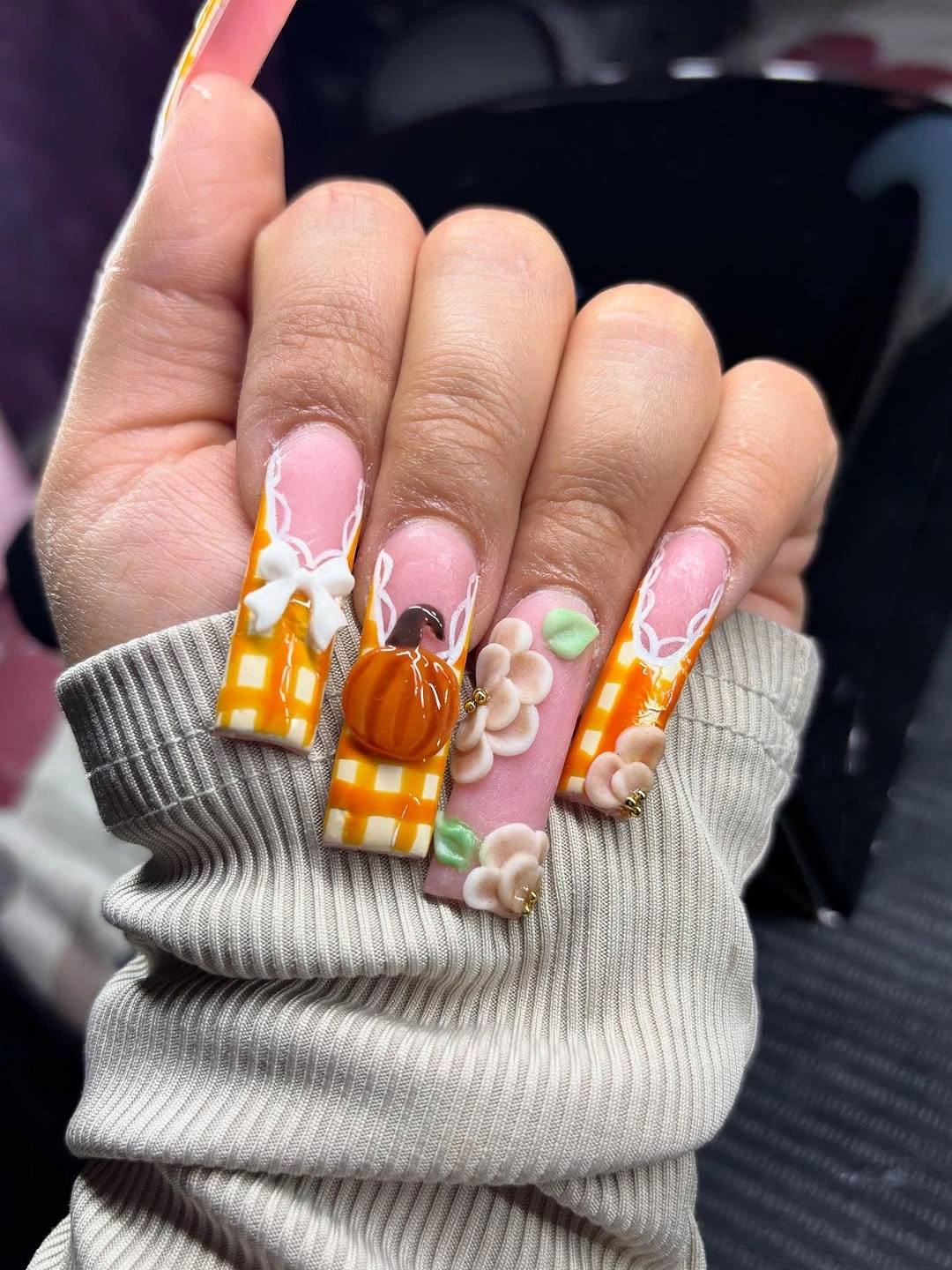 Long pink square nails with raised pumpkins checks and colorful charms