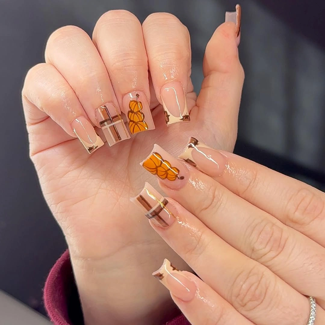 Long clear tipped nails with pumpkin outlines and thin black borders