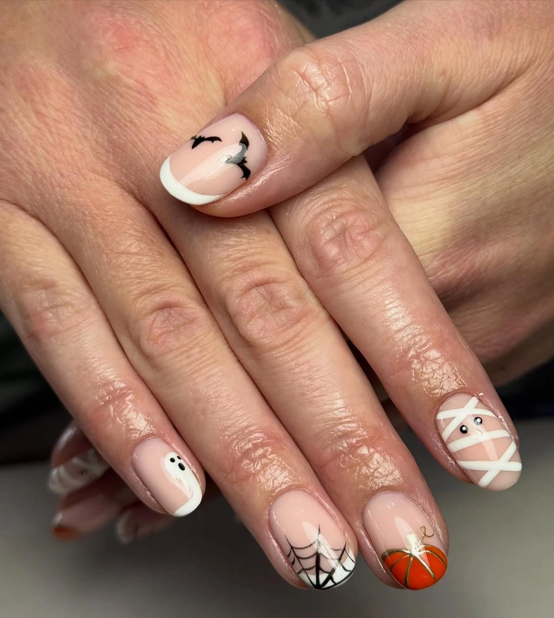 Pale pink short nails with bats ghost web and pumpkin details