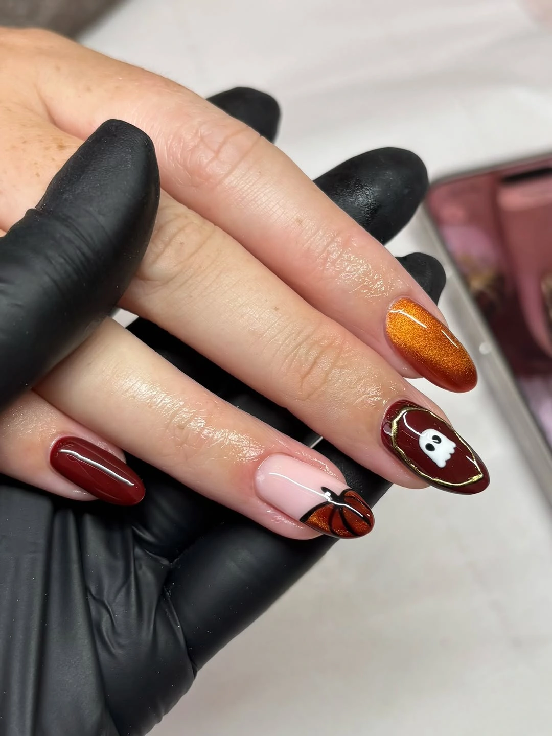 Medium almond nails with burgundy pumpkin ghost mummy and orange accents