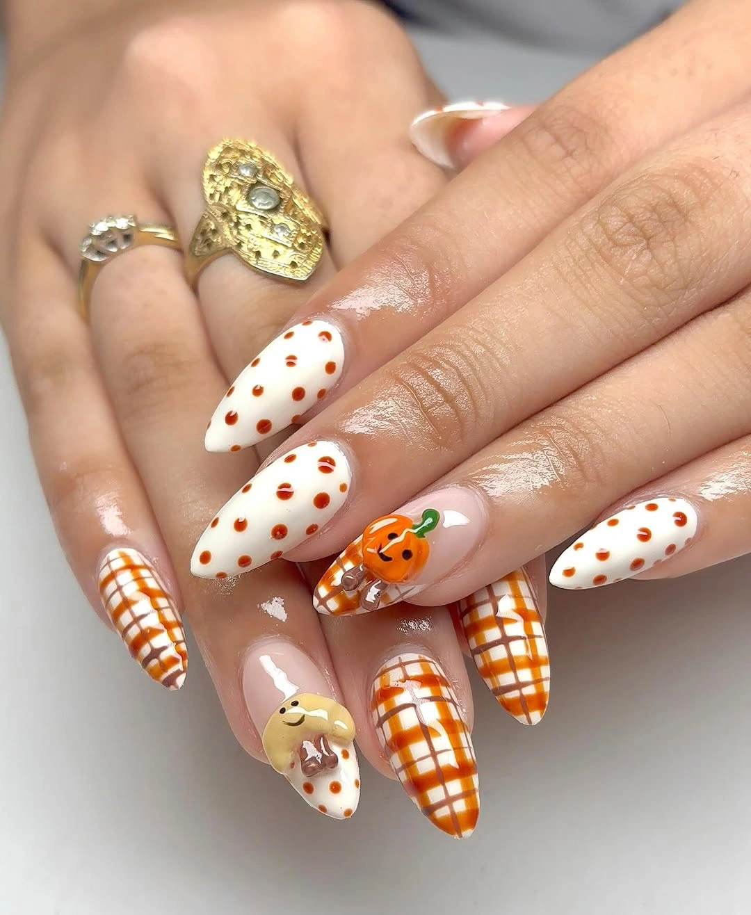 Long almond nails with orange checks dots pumpkin and ghost accents