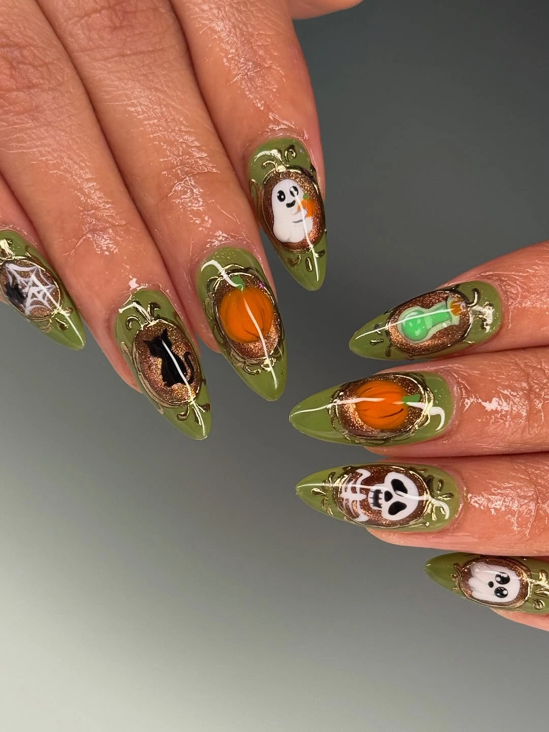Olive green stiletto nails with pumpkins ghosts webs and skeleton details