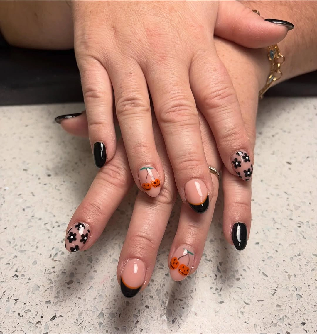 Nude stiletto nails with black tips pumpkins and floral Halloween art