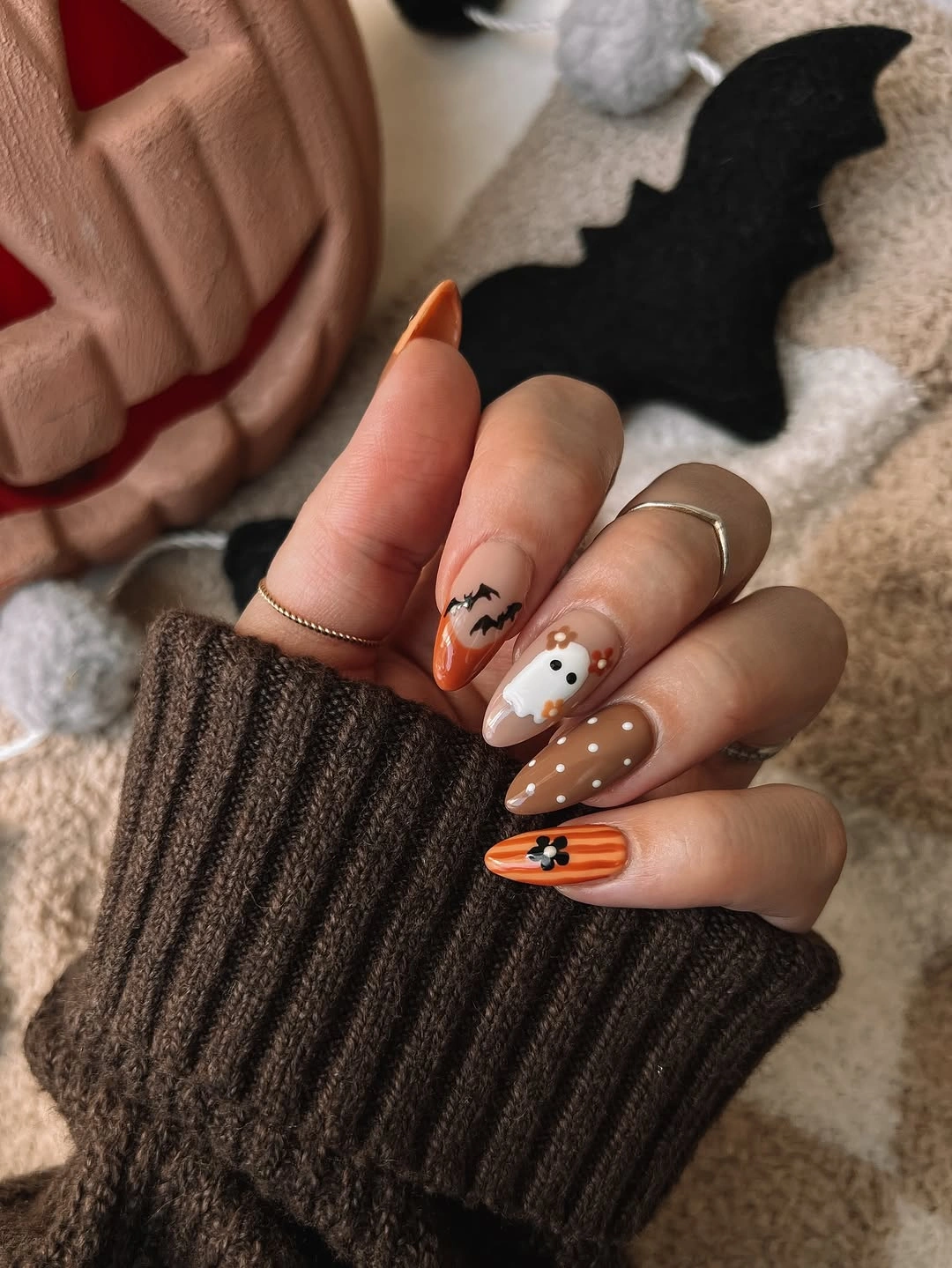 Medium almond orange black white nails with small Halloween icons