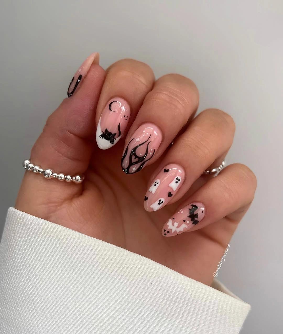 Medium almond pink white nails with delicate black web illustrations