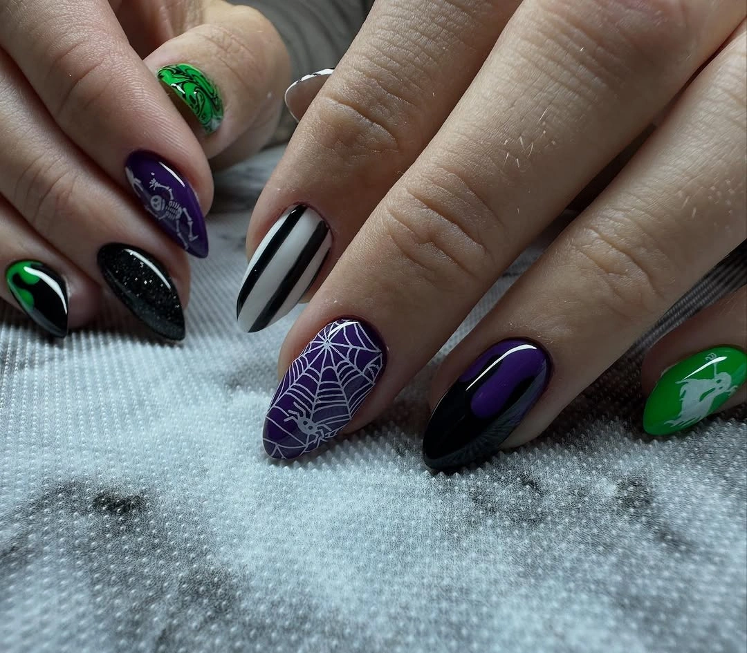 Medium almond black purple nails with one green accent and web detail