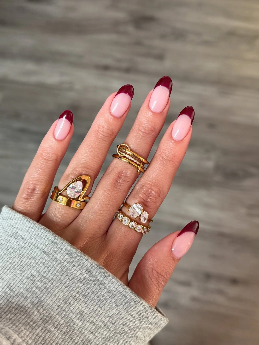 Pale pink almond nails with clean burgundy French tips