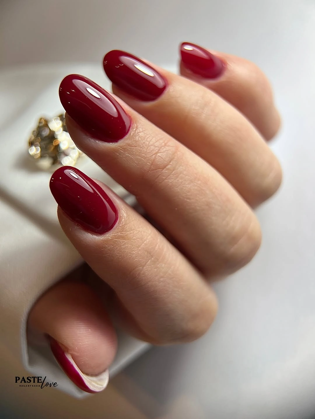Medium oval nails in a bright glossy wine red burgundy shade