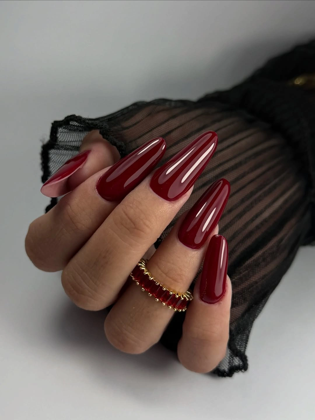 Long glossy burgundy coffin nails in an even rich red-maroon color