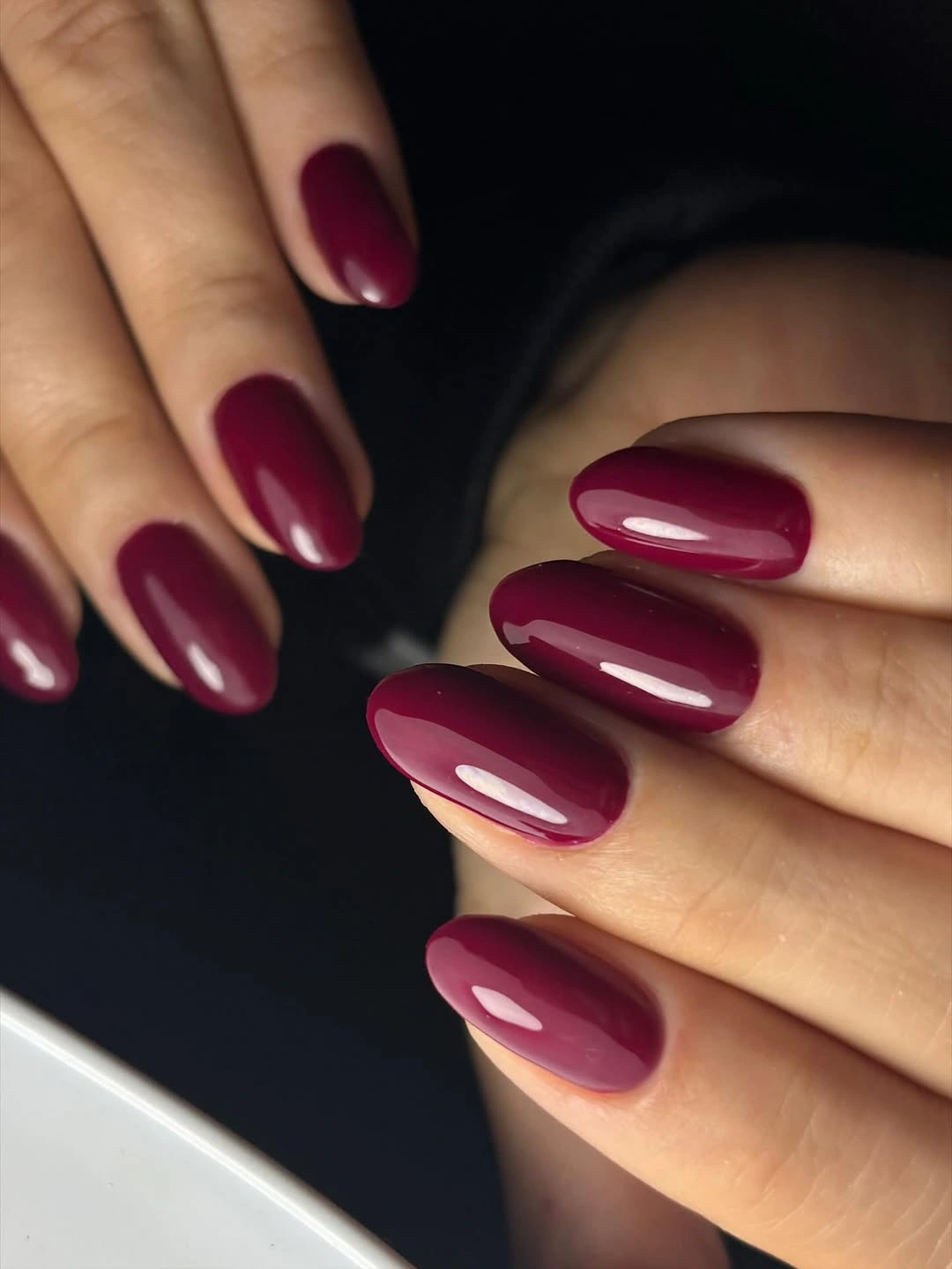 Long oval nails in a smooth glossy medium-deep burgundy color