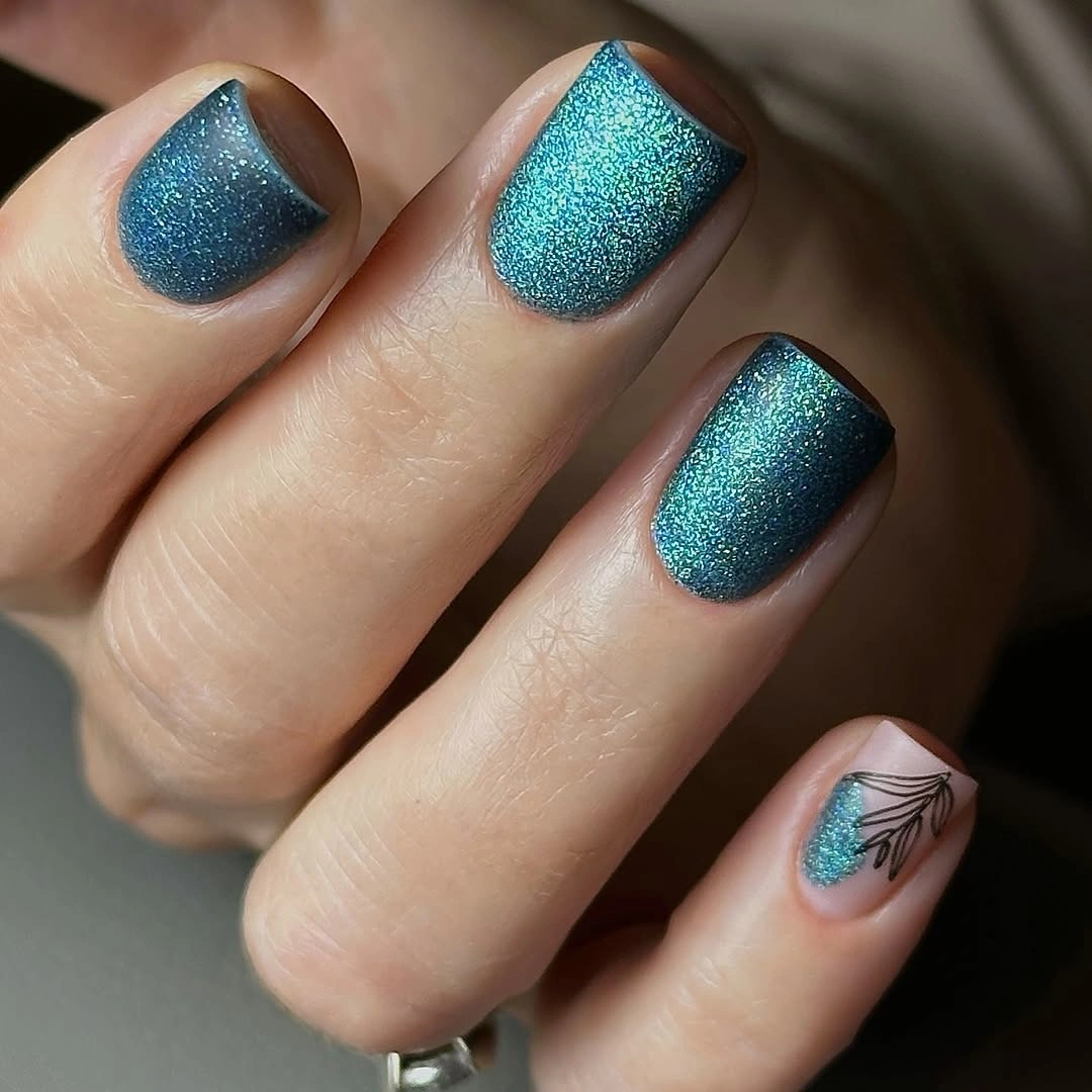 Short teal shimmer nails with a pale botanical leaf accent nail