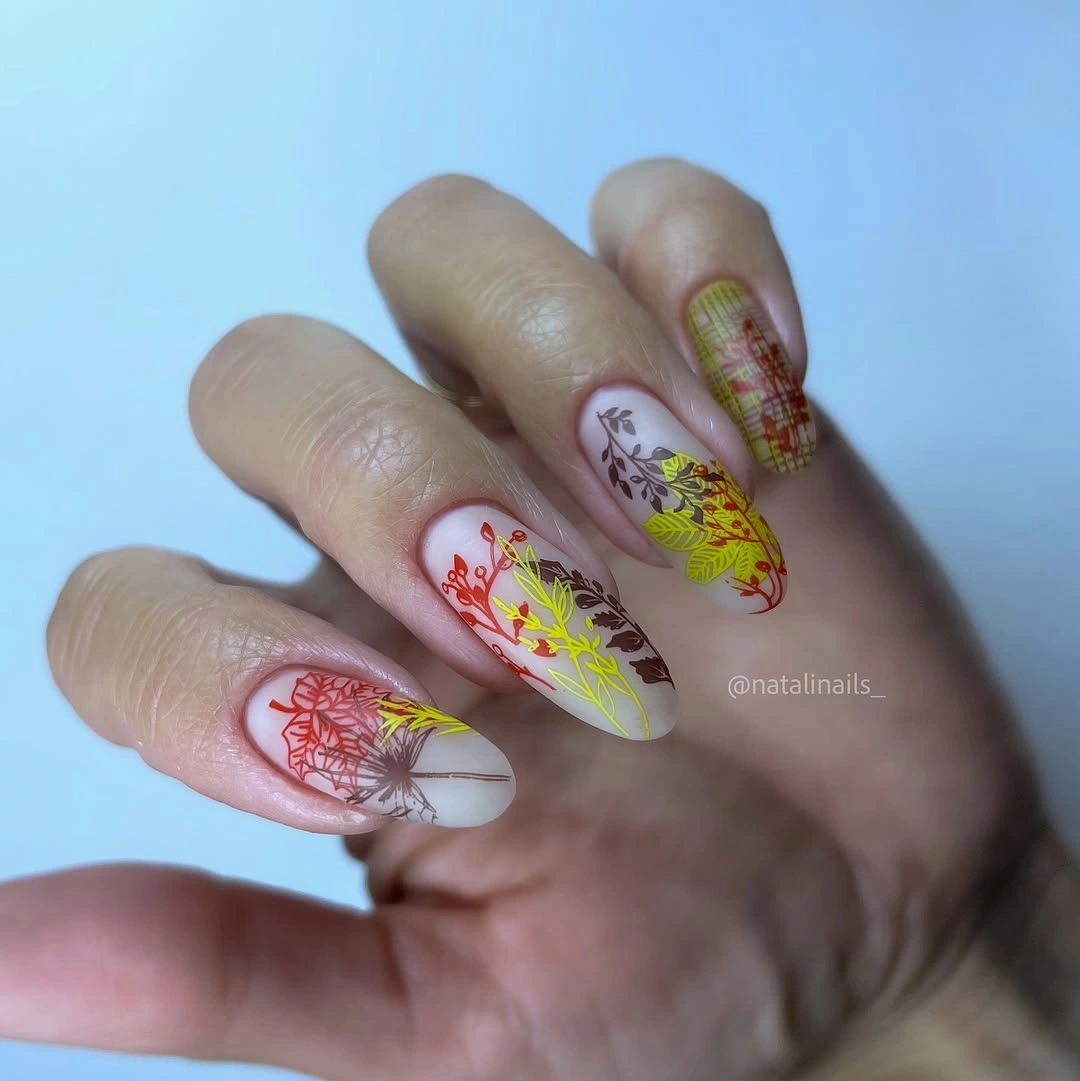 Ivory almond nails with autumn leaves and a small plaid accent