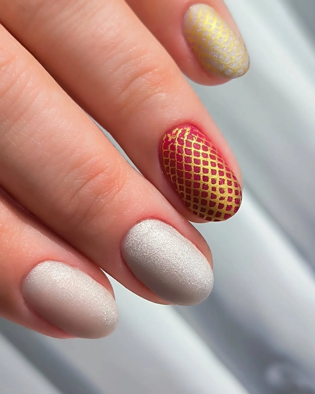 Matte pearl nails with berry red and fine gold lattice accent