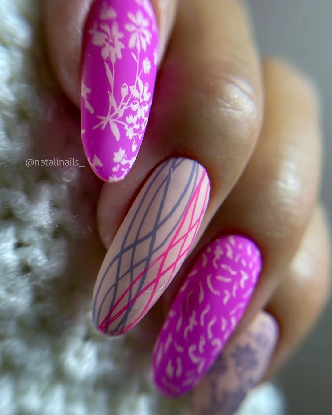 Bright magenta matte almond nails with floral and graphic nude accents