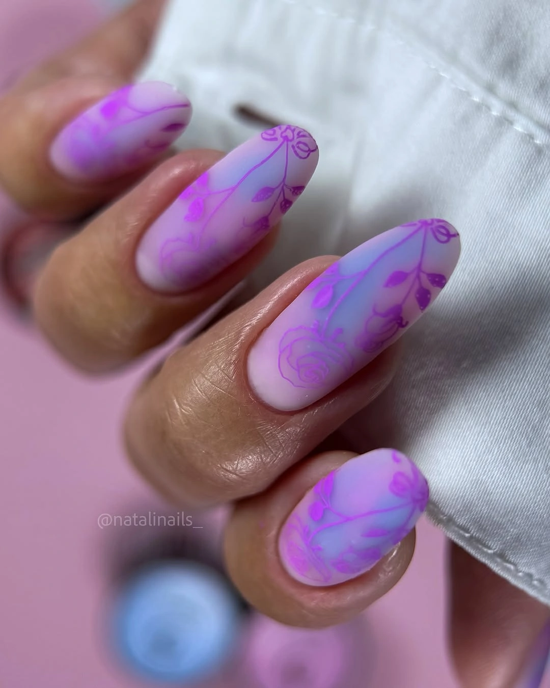 Lavender almond nails with layered violet swirls and abstract patches